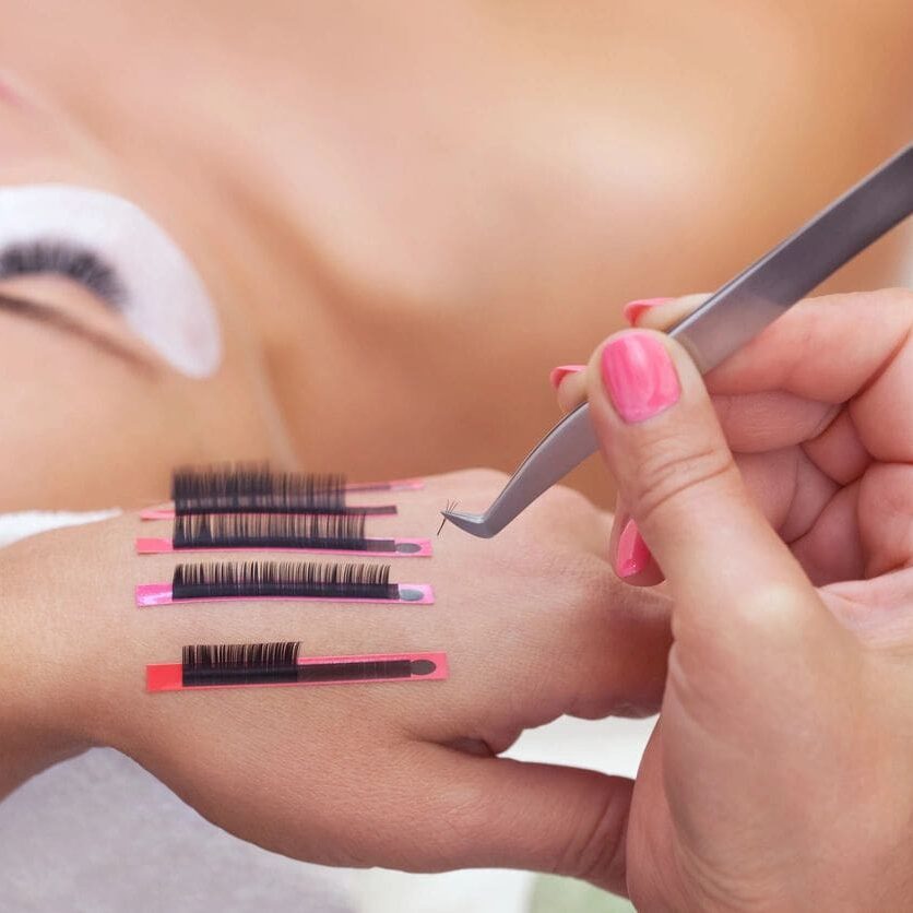 A woman getting her nails done by a stylist.